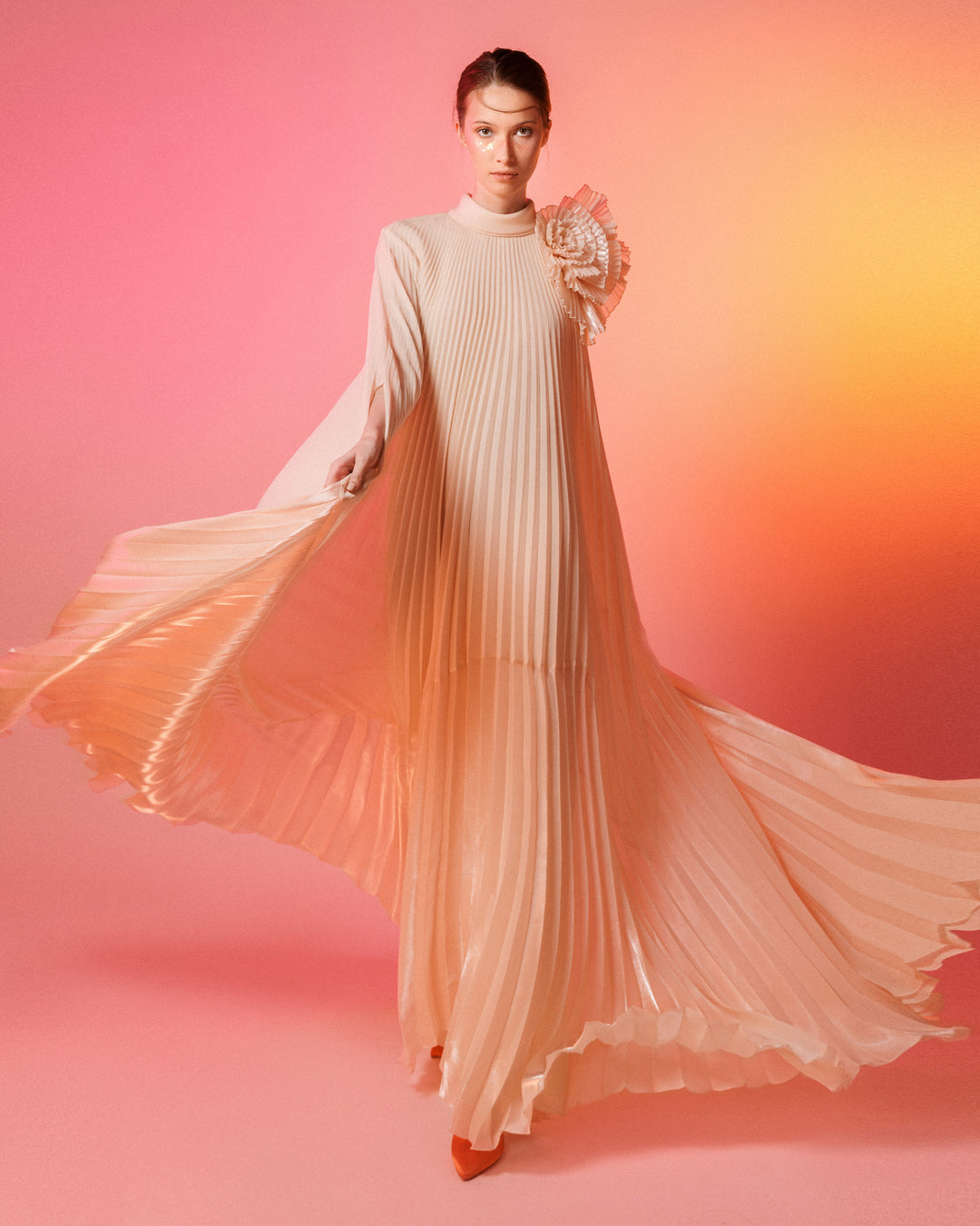 A fully pleated lame organza flared beige dress with an embellished draped flower on the shoulder.