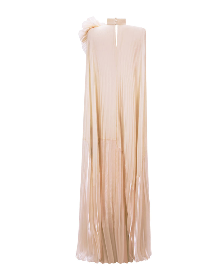 The back of a fully pleated lame organza flared beige dress with an embellished draped flower on the shoulder.