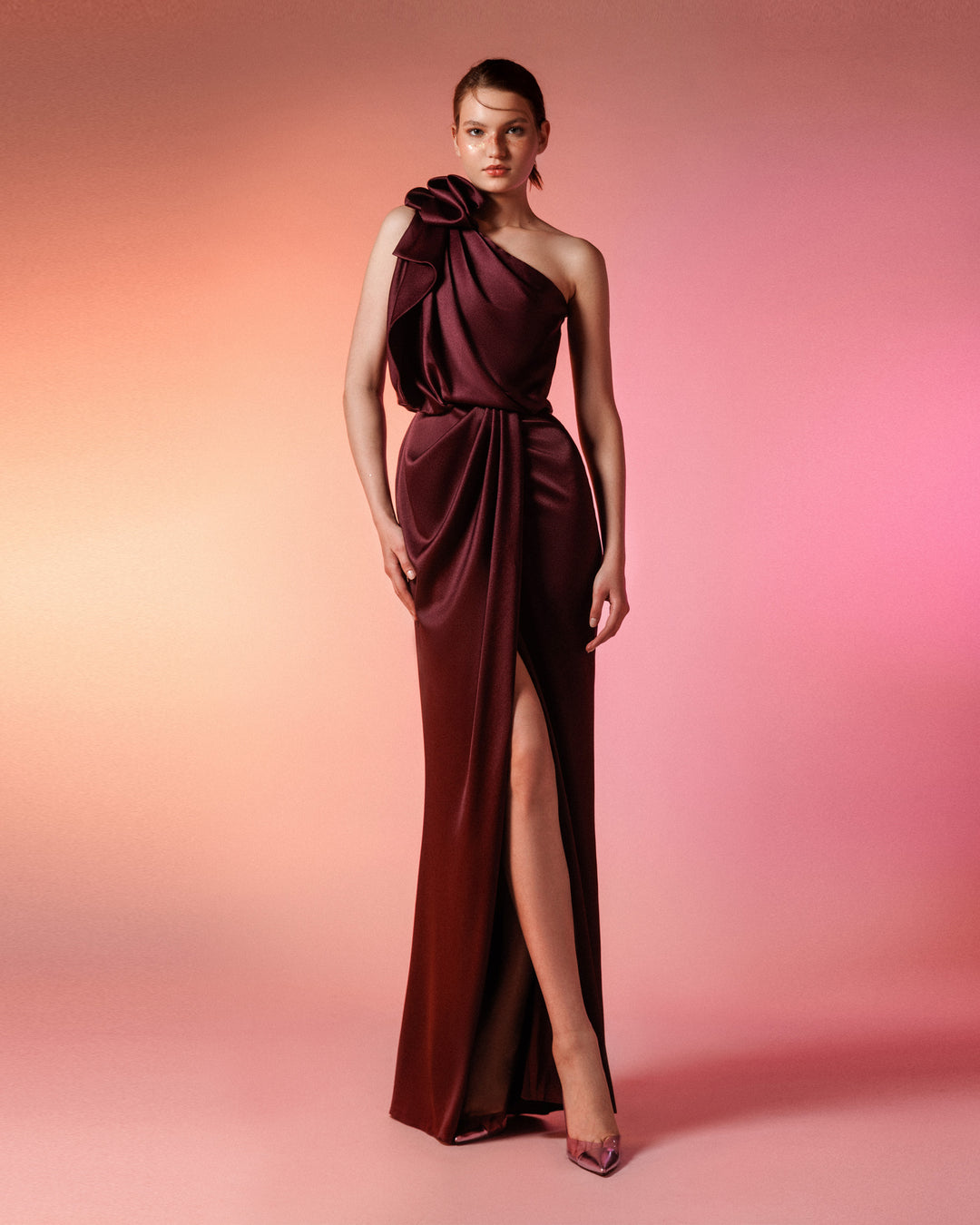 A one-shoulder satin dress with draping details and open slit in the middle.