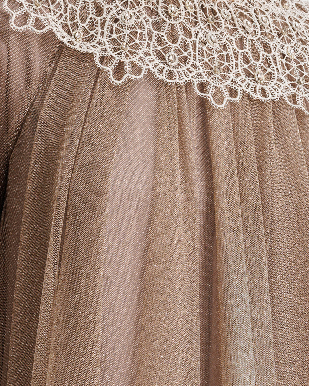 A close-up of a shiny tulle fabric in taupe color overlayed with lace.