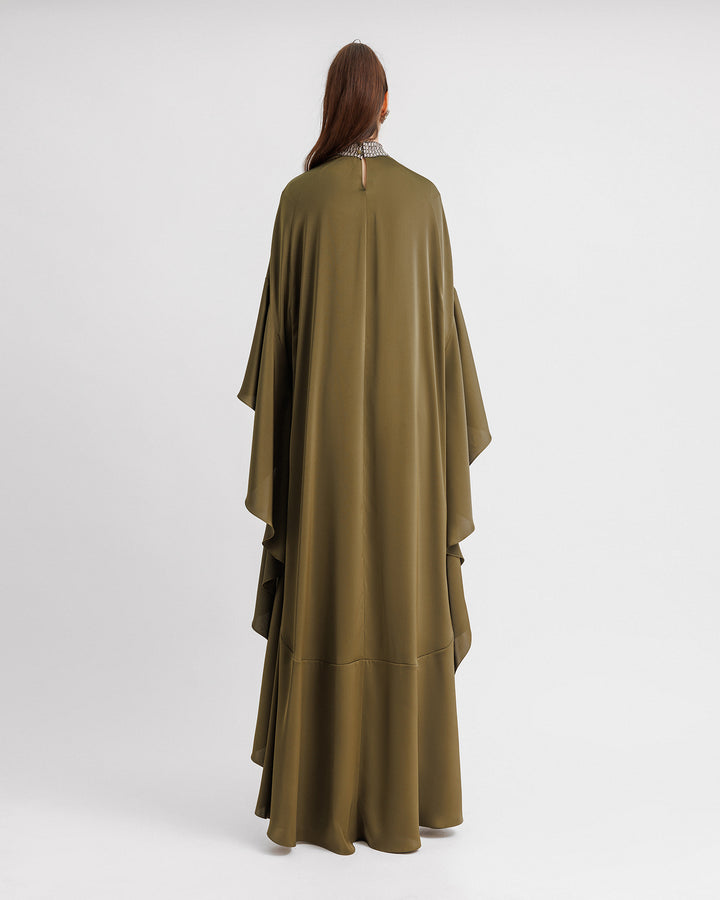 The back of a kaftan-style evening dress in olive green color with a beaded collar and ruffled floor-length sleeves.