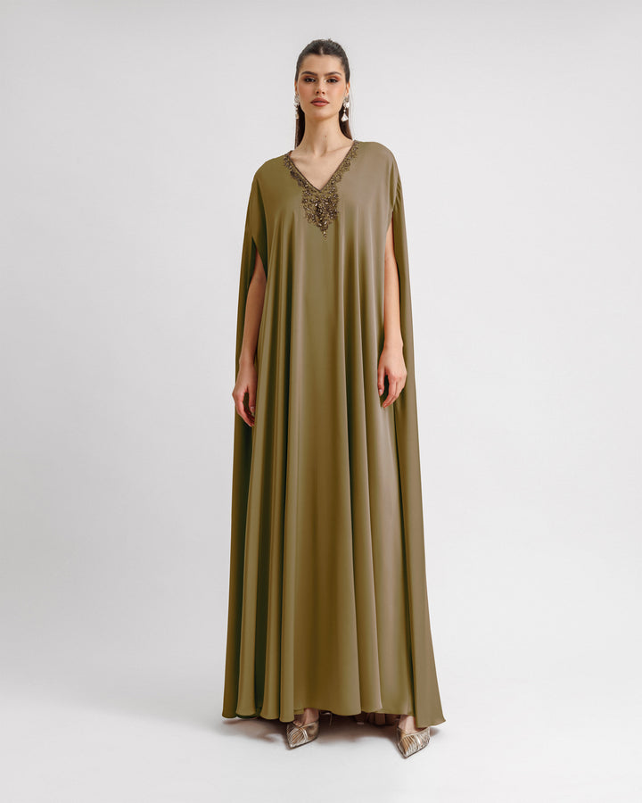 A kaftan-style satin evening dress in olive green color with a beaded V-neckline.