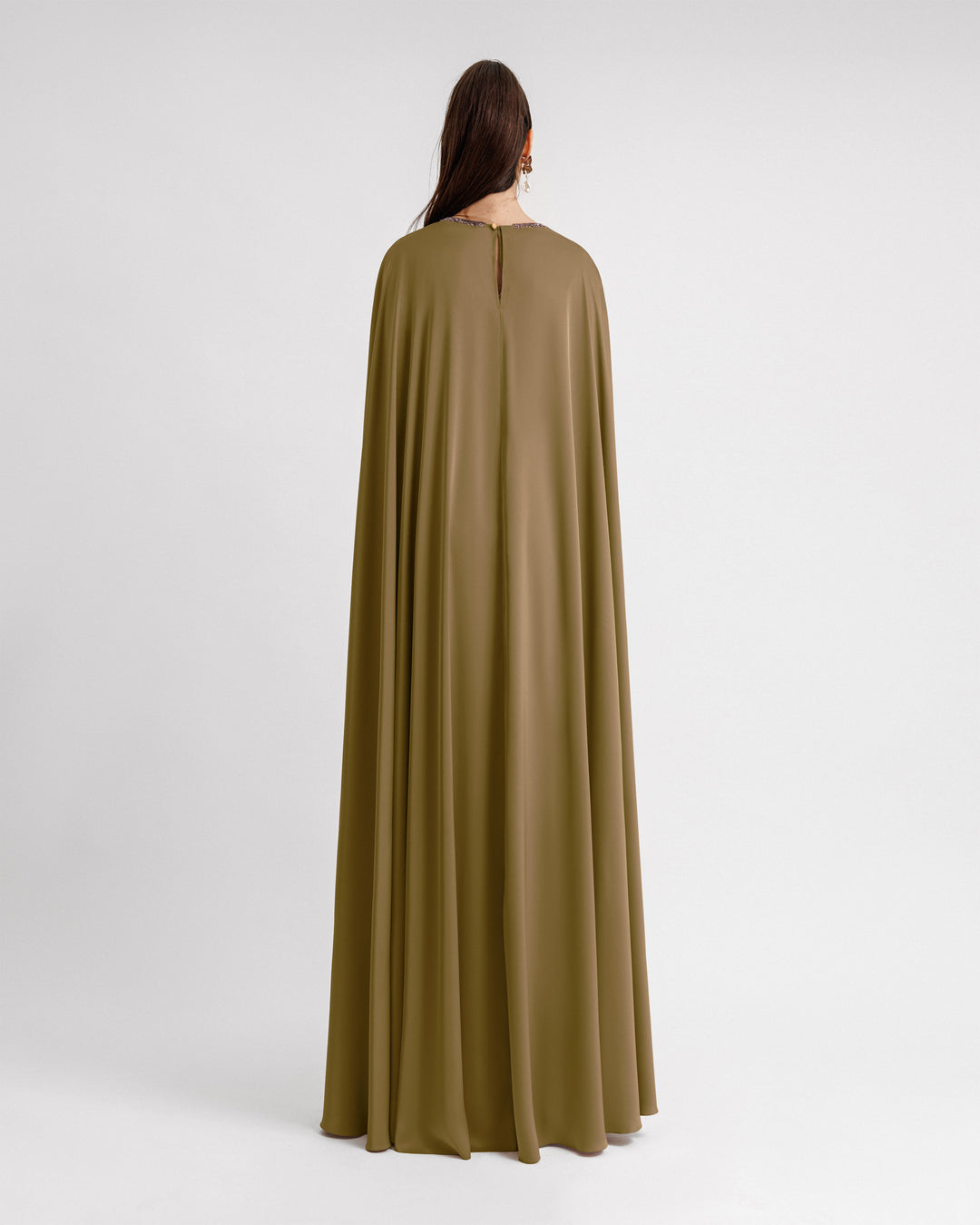 The back of a kaftan-style satin evening dress in olive green color.