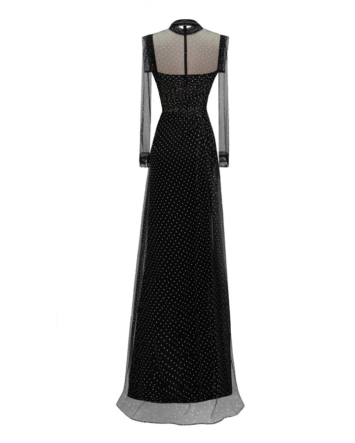 The back of a strapless draped black dress with a slit on the side, paired with a detachable see-through long sleeve top.