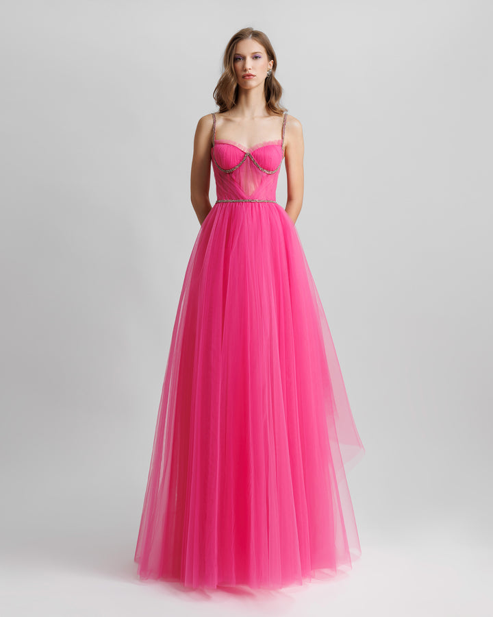 A fuchsia tulle dress featuring beaded straps and a draped corset.