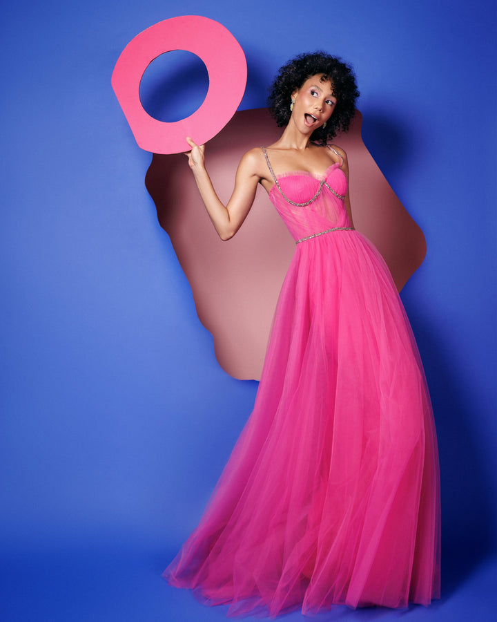 A fuchsia tulle dress featuring beaded straps and a draped corset.