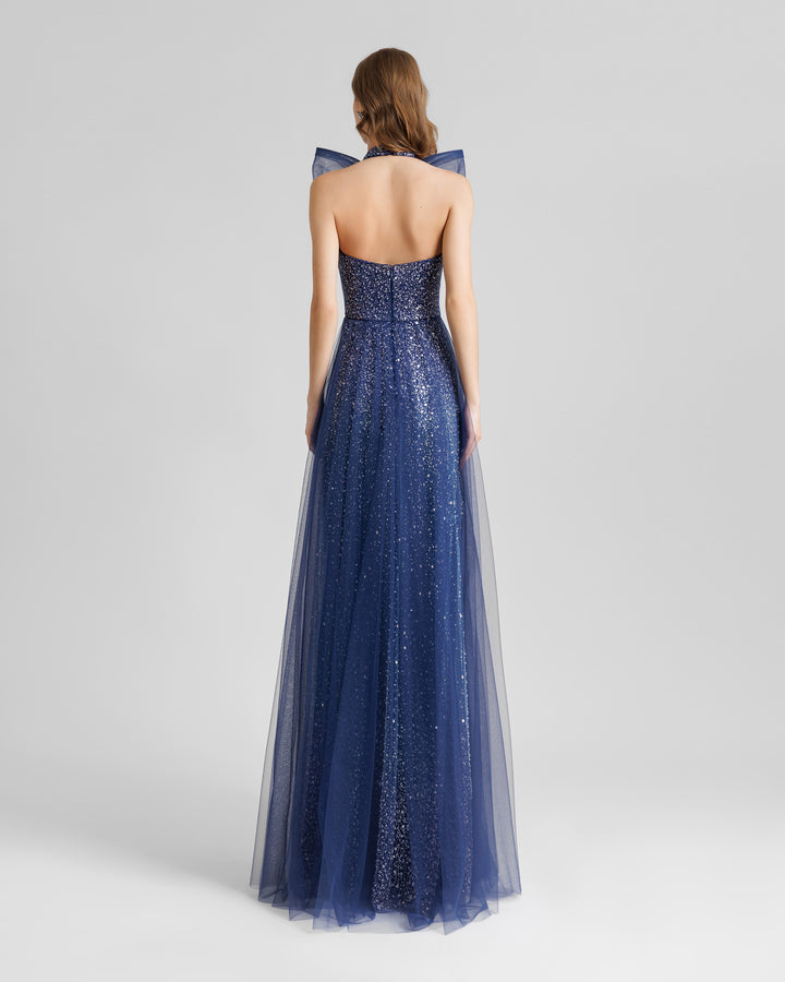 The back of an halter-neck blue evening dress with an open back and a beaded underlayer.