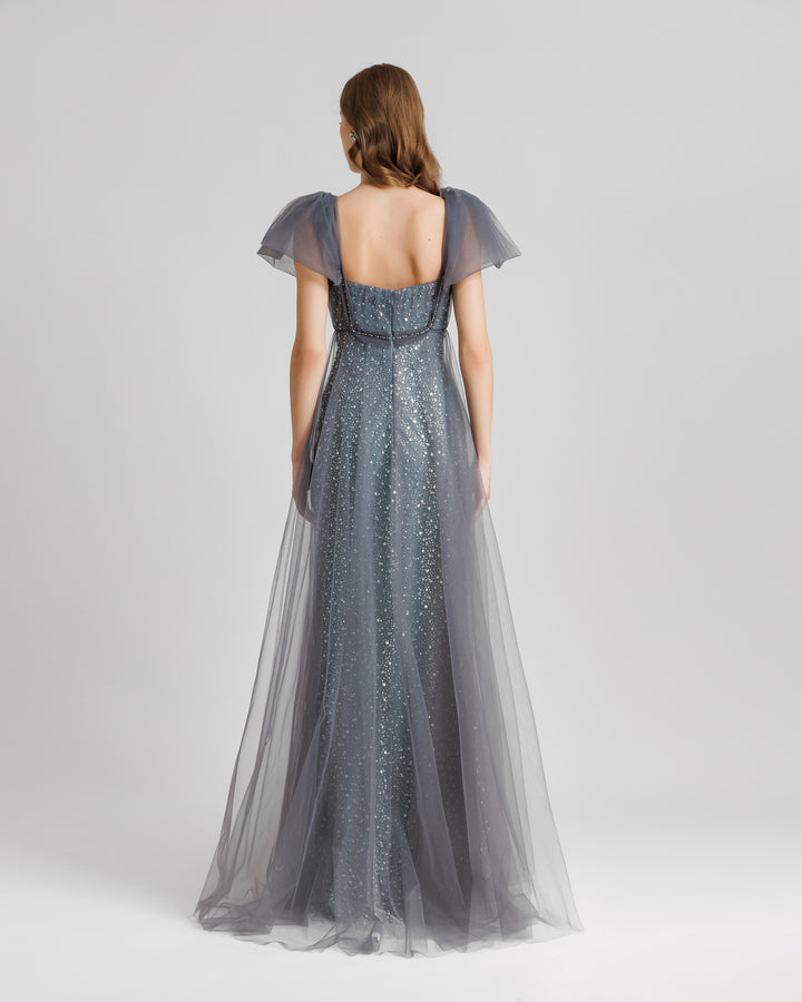 The back of a loose-cut grey dress with puffed tulle sleeves and a beaded underlayer.