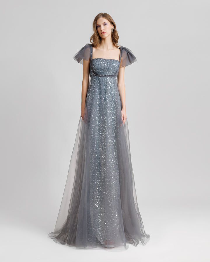 A loose-cut grey dress with puffed tulle sleeves and a beaded underlayer.