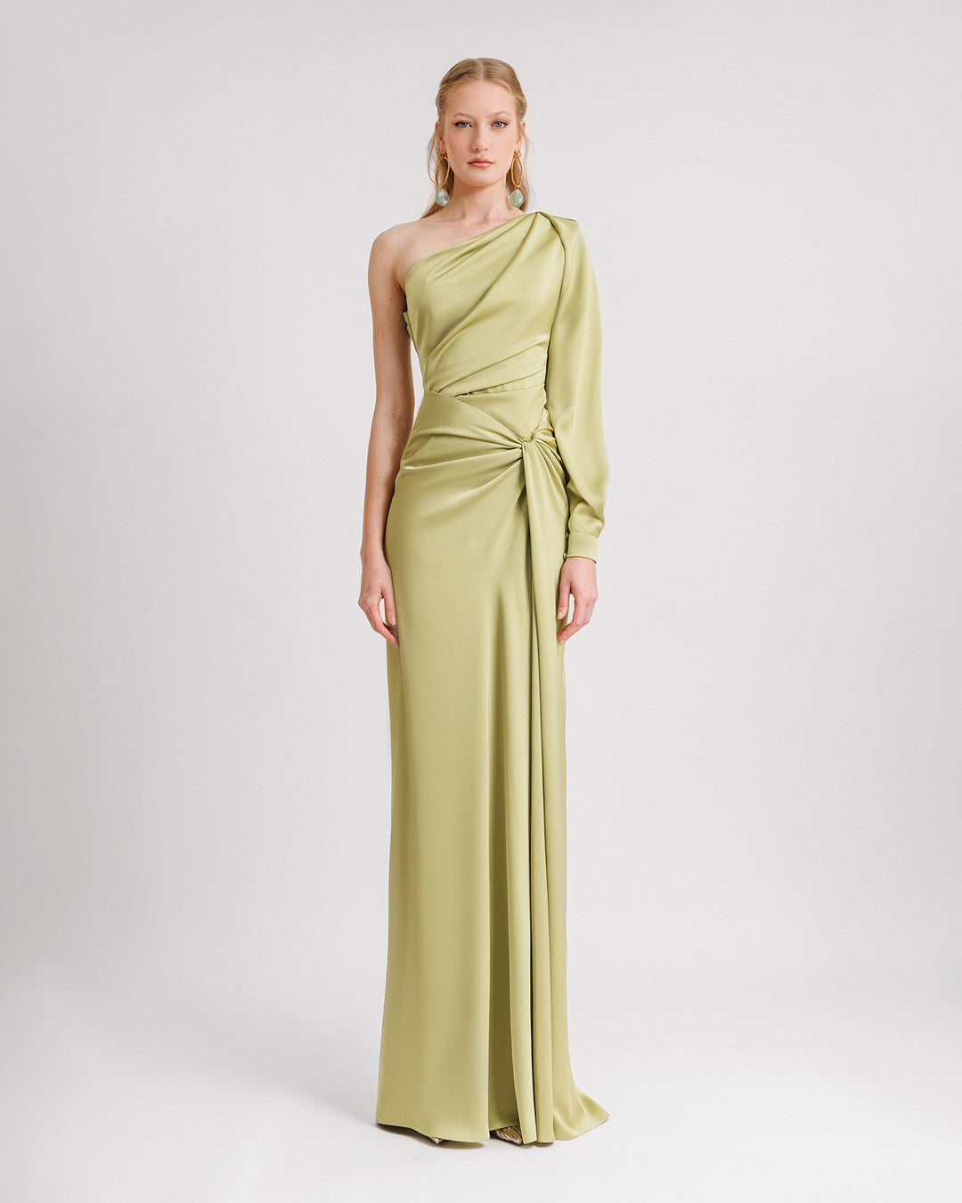 A one-shoulder long sleeve draped evening dress in pistachio satin fabric.