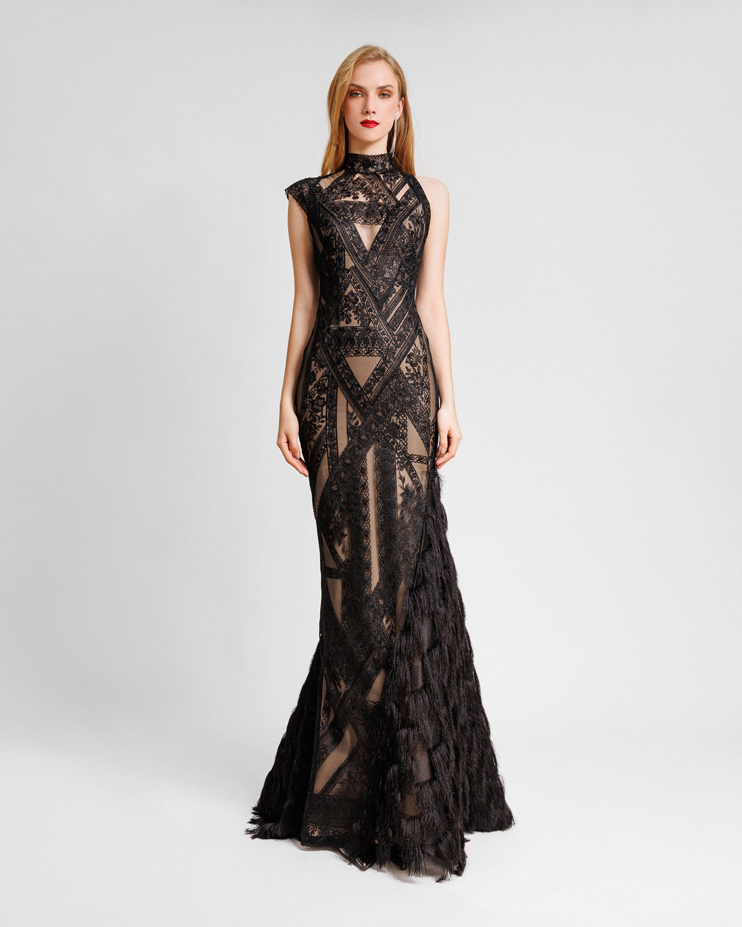 An asymmetrical mermaid cut evening dress in black patterned lace fabric with a single-side fringed hemline.