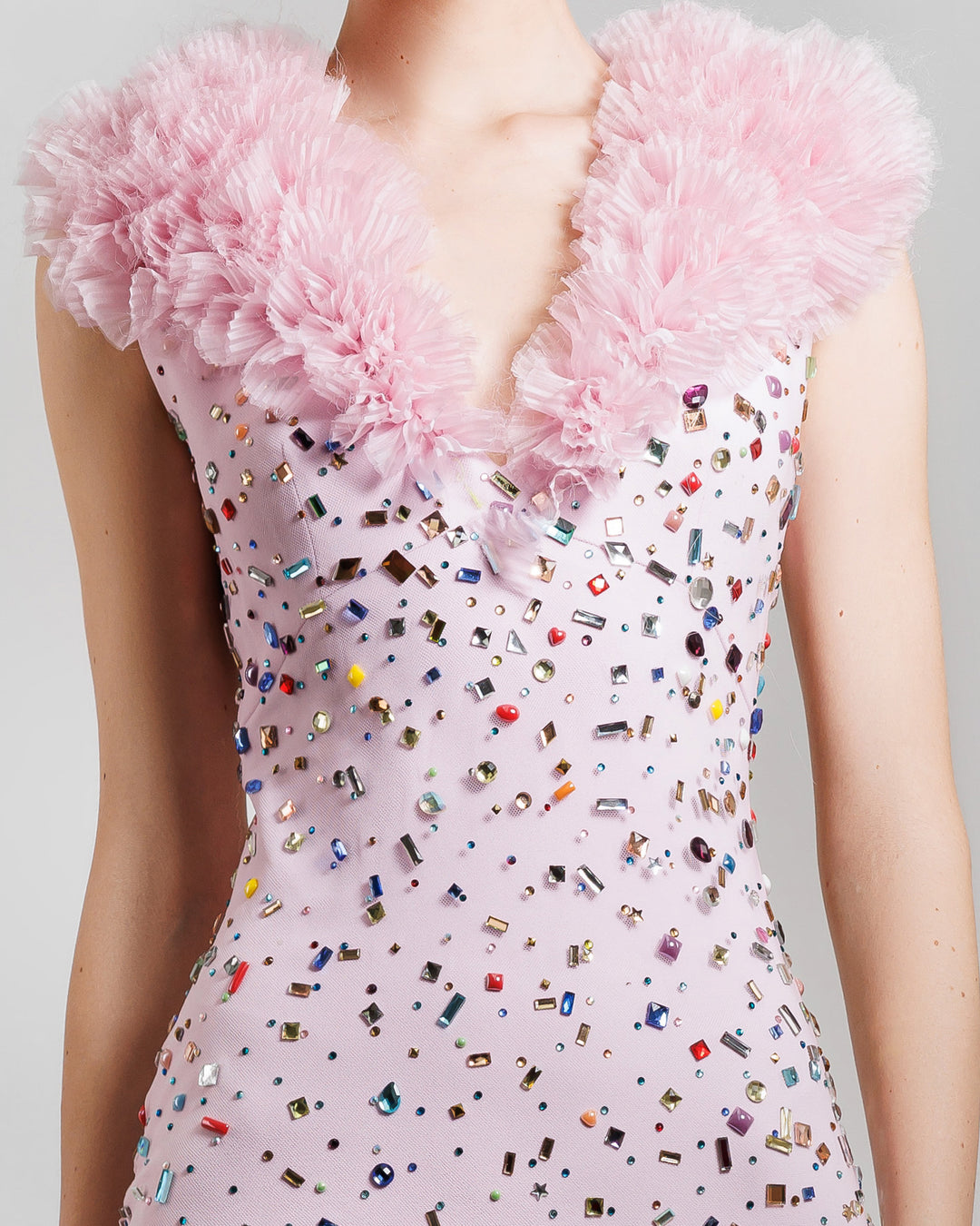 A close-up of a fully multicolor beaded pink midi dress featuring a V- Neckline with rushed organza detail.