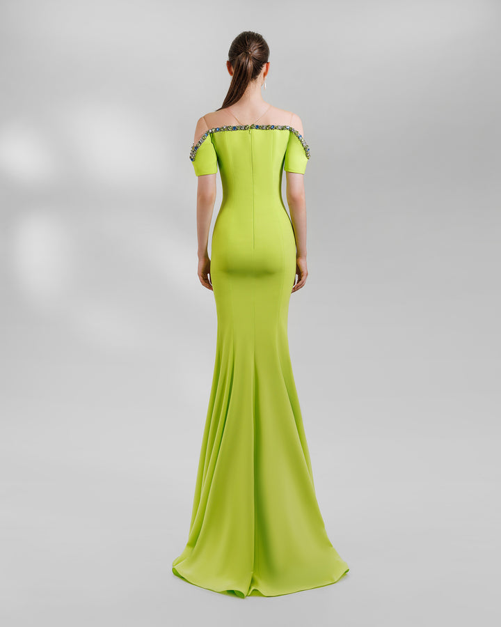 The back of a lime long evening dress with a beaded neckline that is off the shoulders. This design is featuring a mermaid cut.