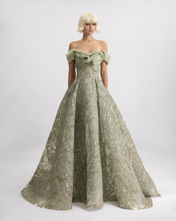 An off-the-shoulder sage evening dress with organza draping at the neckline and a draped skirt.