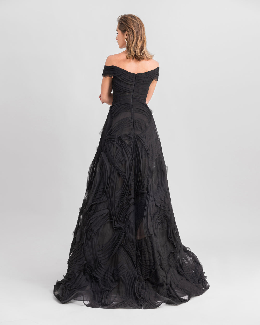 The back of an off-the-shoulders black tulle evening dress with a full wide skirt.