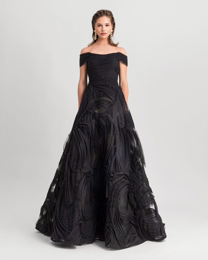 An off-the-shoulders black tulle evening dress with a full wide skirt.