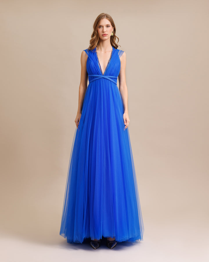 A deep v-cut beaded neckline, flared cut tulle long blue dress with ribbon design on the waist.