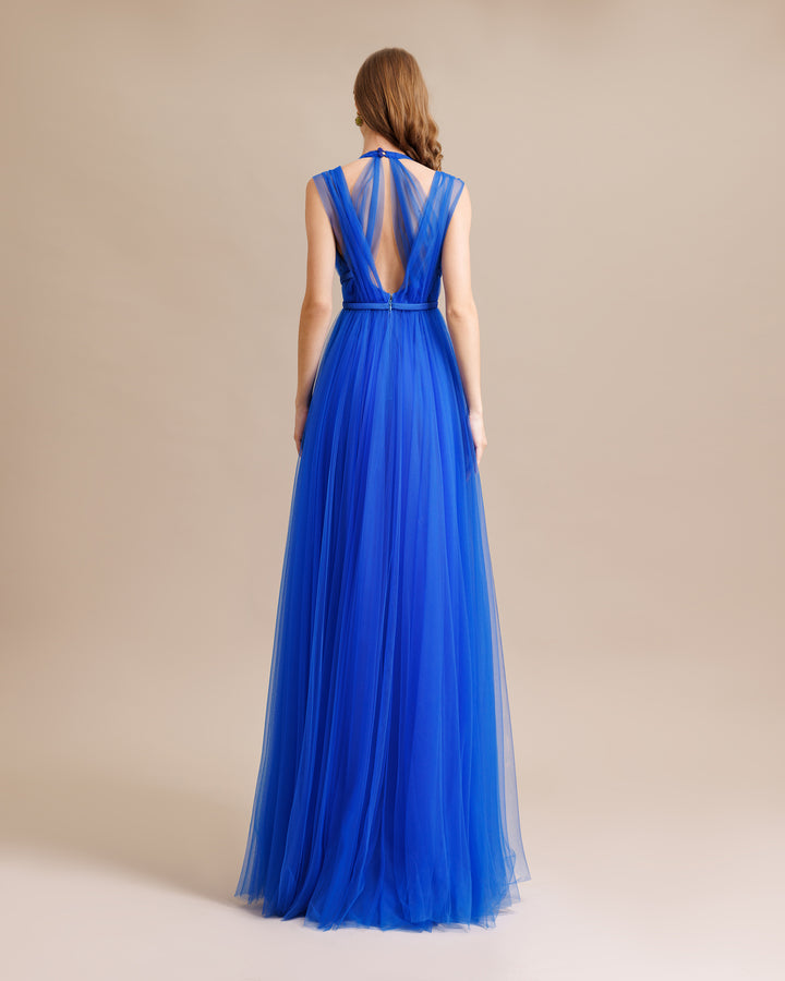 The back of a v-cut backless, flared cut tulle long blue dress.