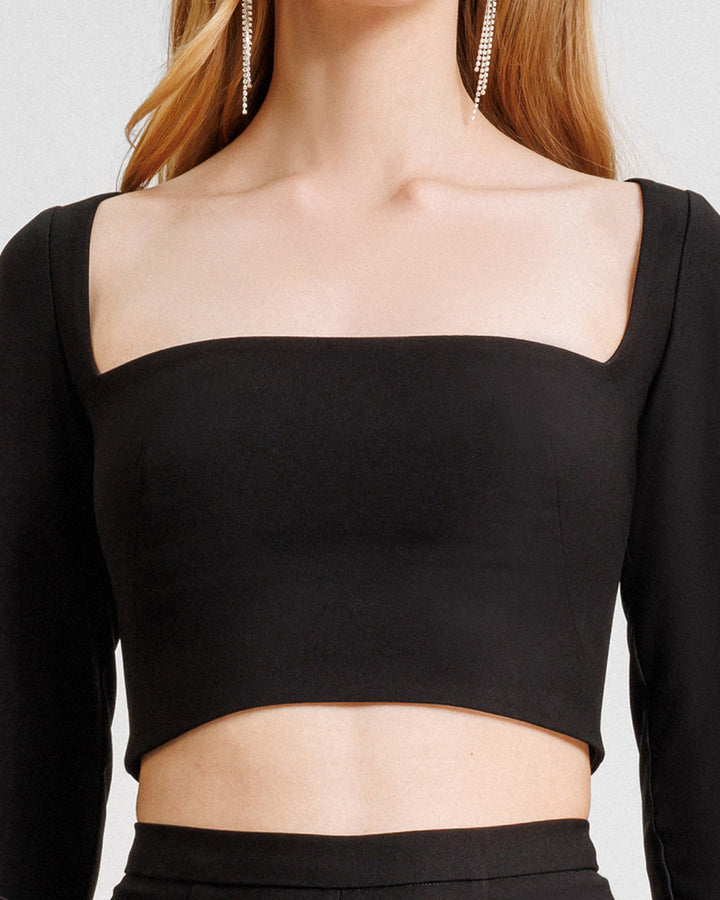 A close-up of a squared-neckline black top.