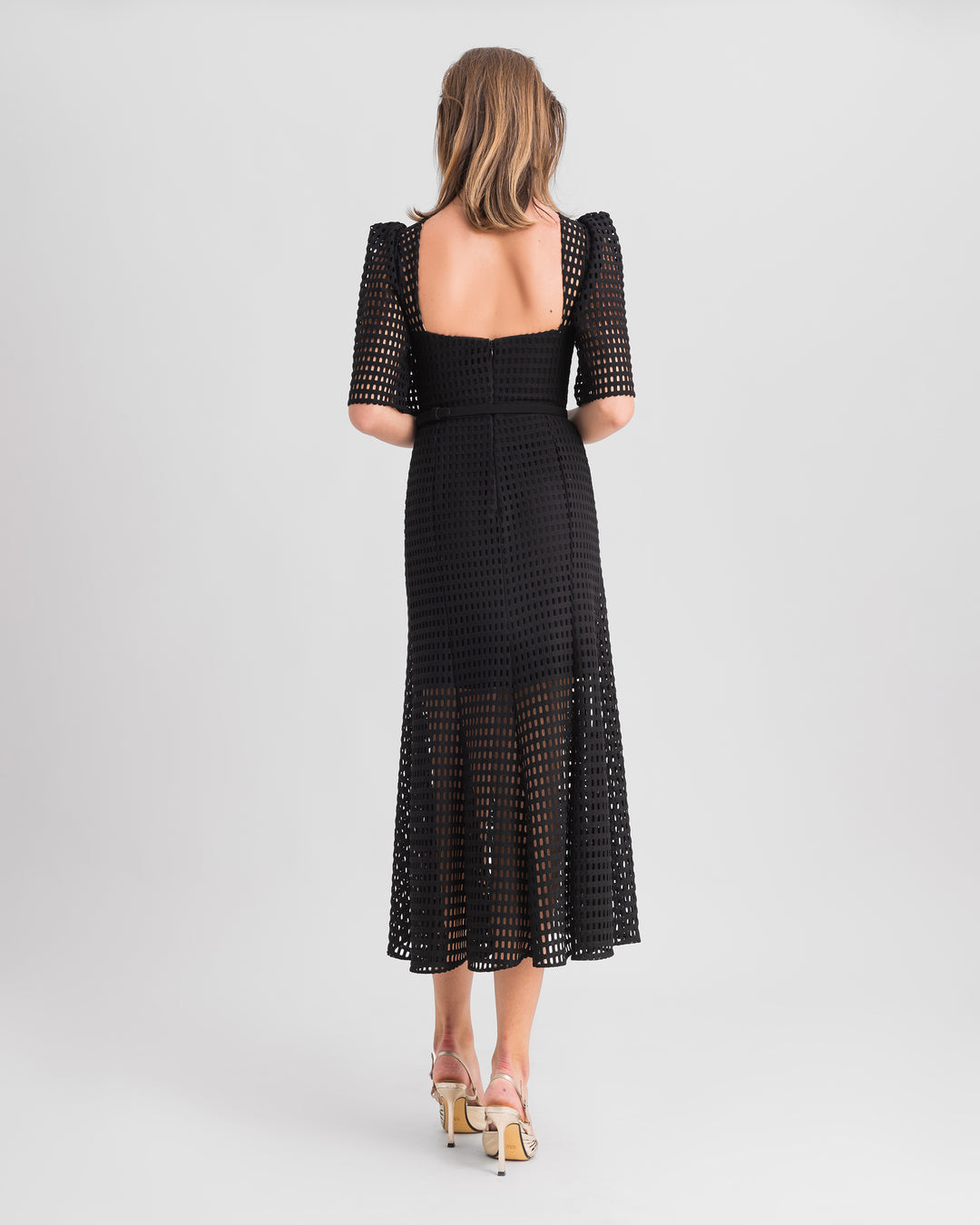 An open back of a crochet lace flared midi dress with puffed sleeves and a detachable belt.