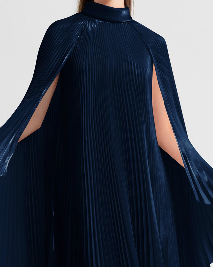 A close-up of a high neckline fully pleated flared navy organza dress with cape-like sleeves.