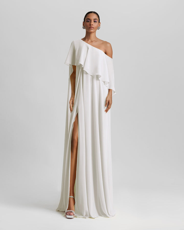 A one-shoulder ivory dress featuring a ruffled cape-like sleeve and a slit on the side.