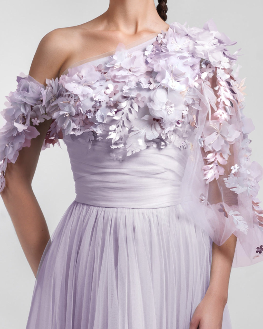 A close-up of a one-shoulder dusty lilac tulle dress with an embellished bodice and a draped waist.