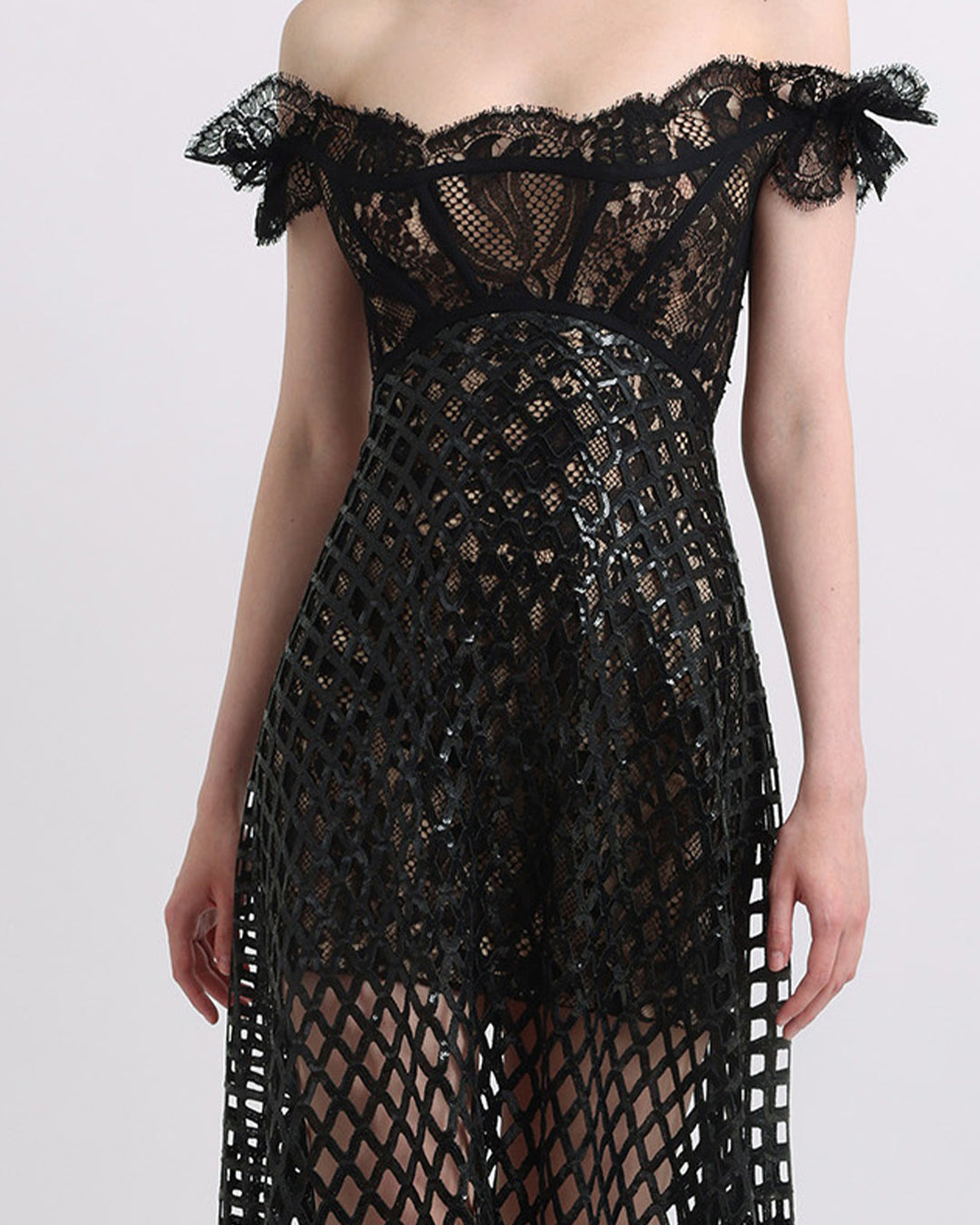 An off-shoulder sequins flared black dress with see-through details.