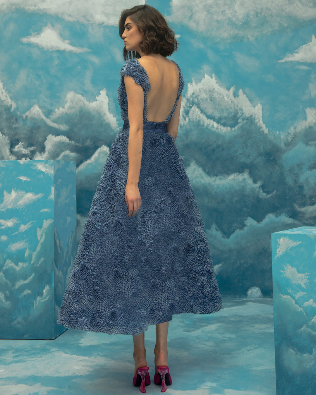 A open back midi blue dress in a fluffy textured chiffon.