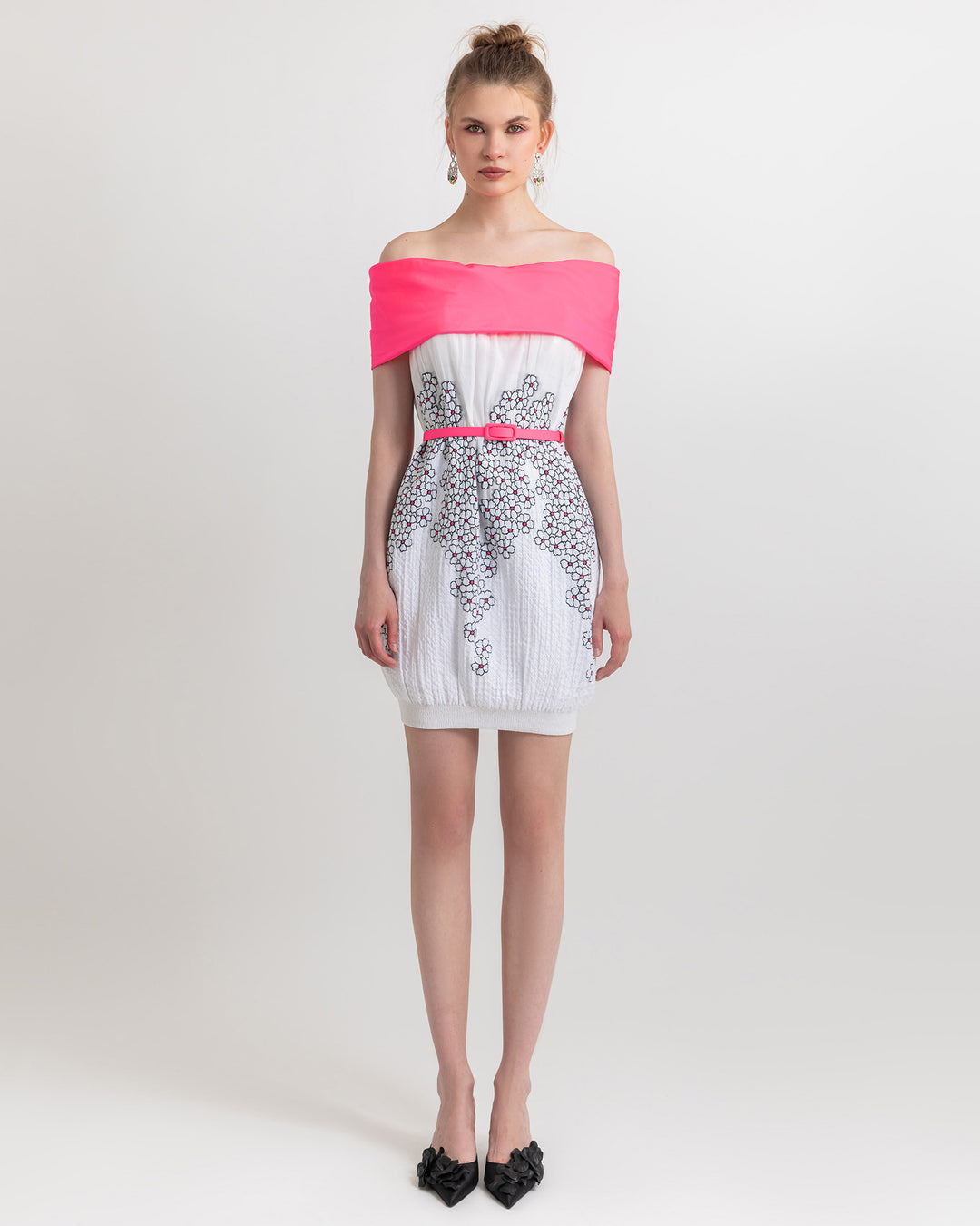 An off-shoulder pink and white dress with floral details, paired with a pink detachable belt.