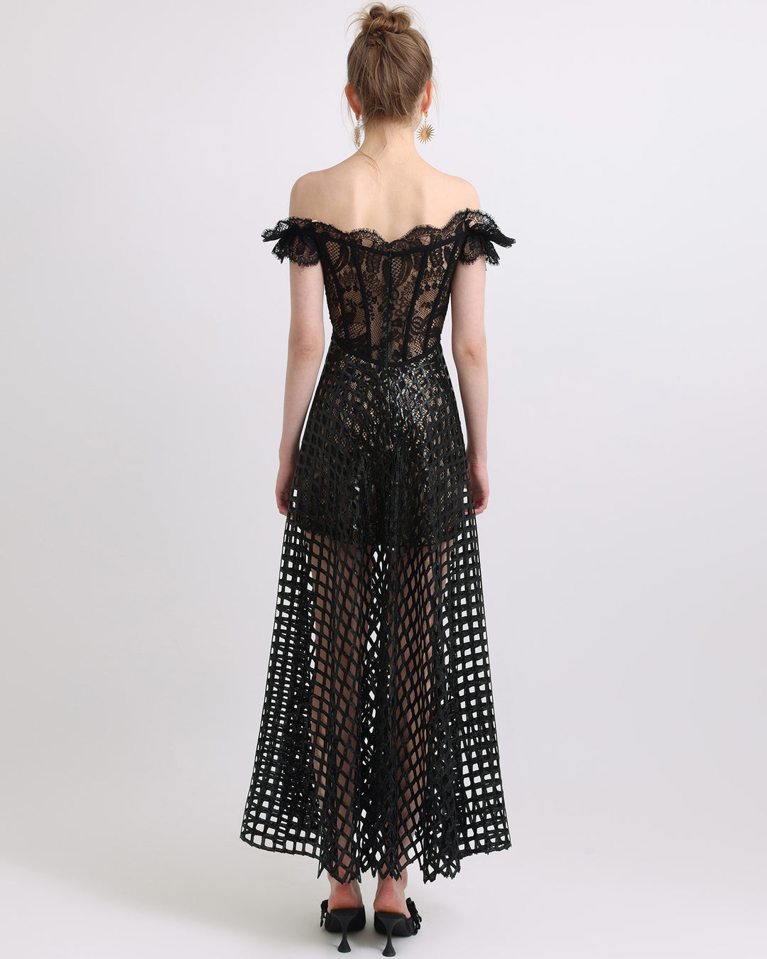 The back of an off-shoulder sequins flared black dress with see-through details.