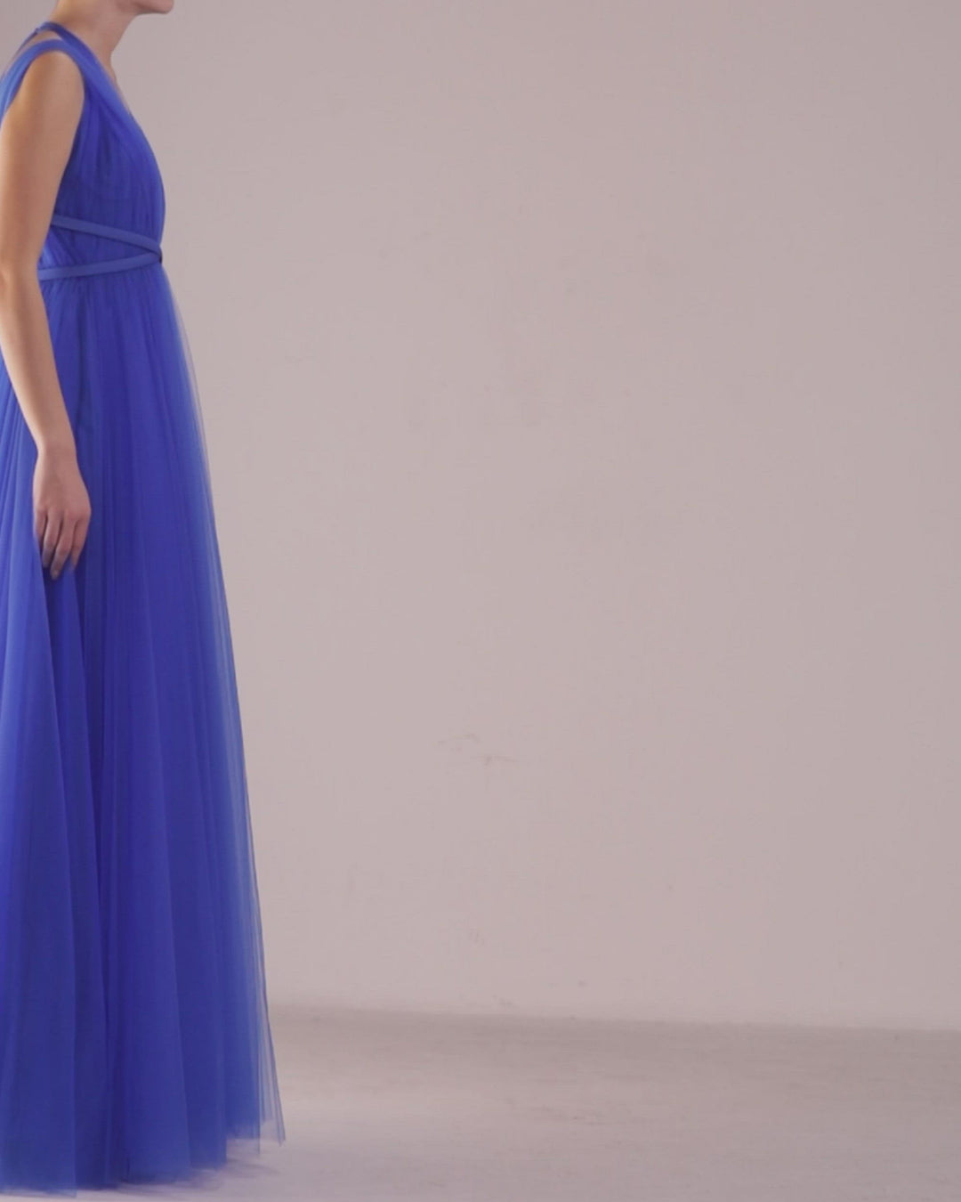 A deep v-cut beaded neckline, flared cut tulle long blue dress with ribbon design on the waist.