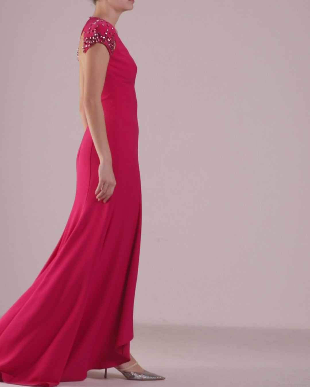 A V-cut neckline long fuchsia evening dress with cut-outs, open back, and embellished details on the shoulder.