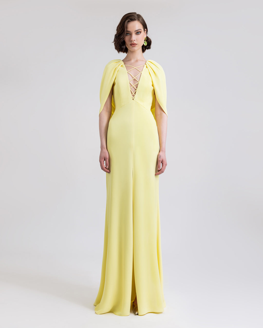 A deep V-neckline long yellow evening dress with cape-like sleeves and open slit in the middle.