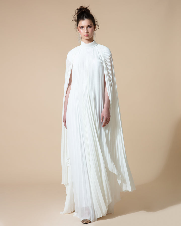 A fully pleated flared chiffon white kaftan dress with cape-like asymmetrical sleeves.