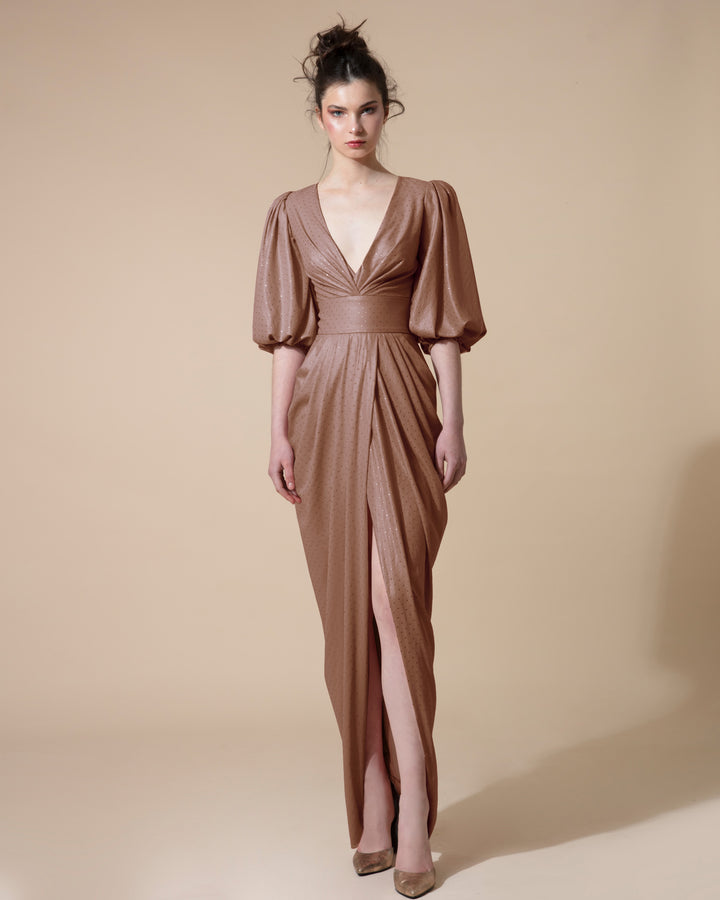 A long brown evening dress with a deep V neck, short bishop sleeves, draping on the waist with an overlapping slit.