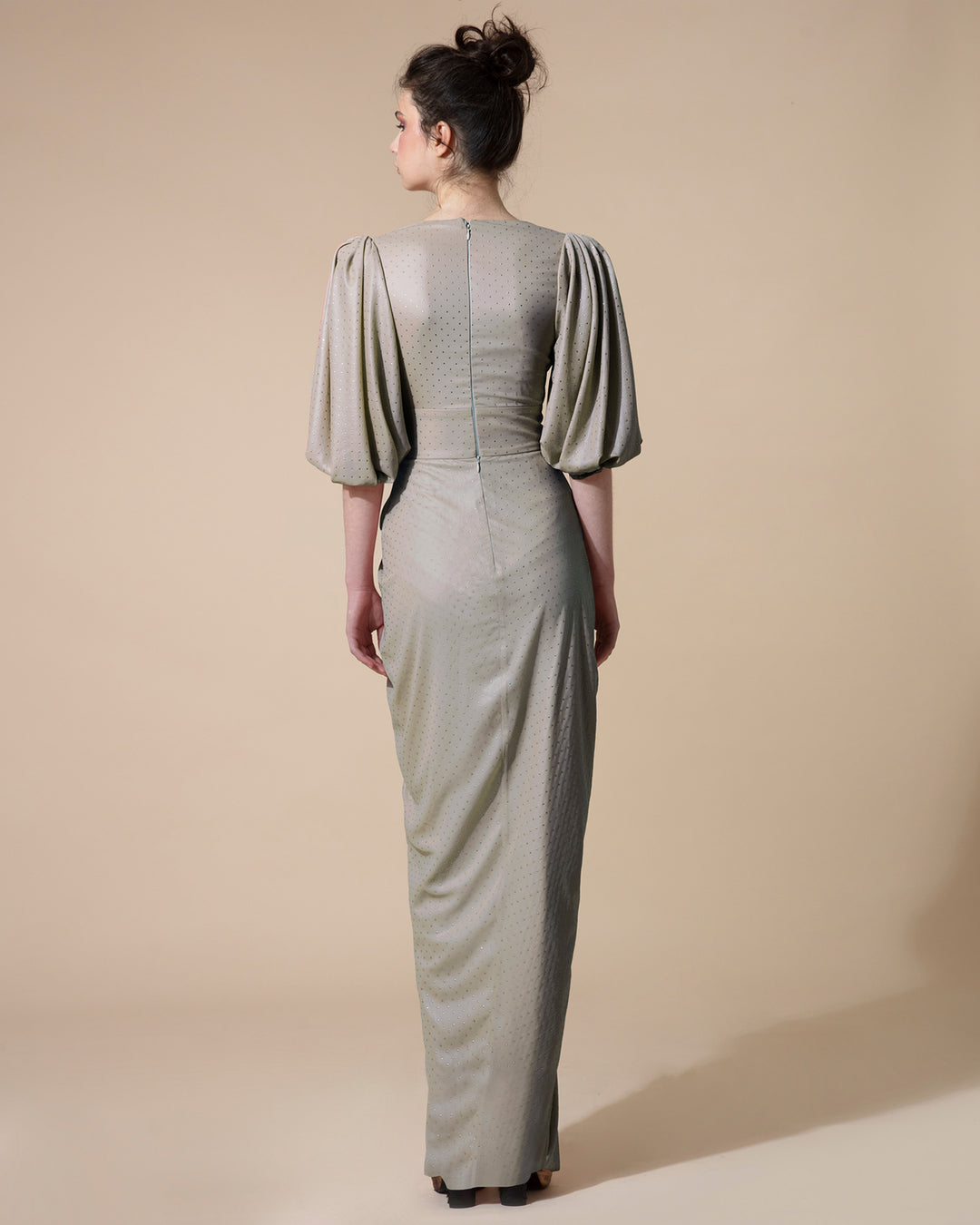 The  back of a long grey evening dress with short bishop sleeves.