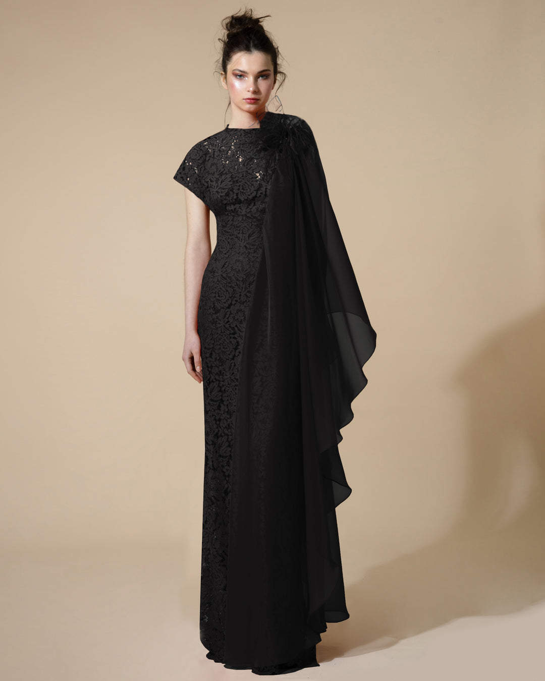 A long fitted black evening dress with short kimono sleeve on one side and draped chiffon sleeve on the other with feathers details.