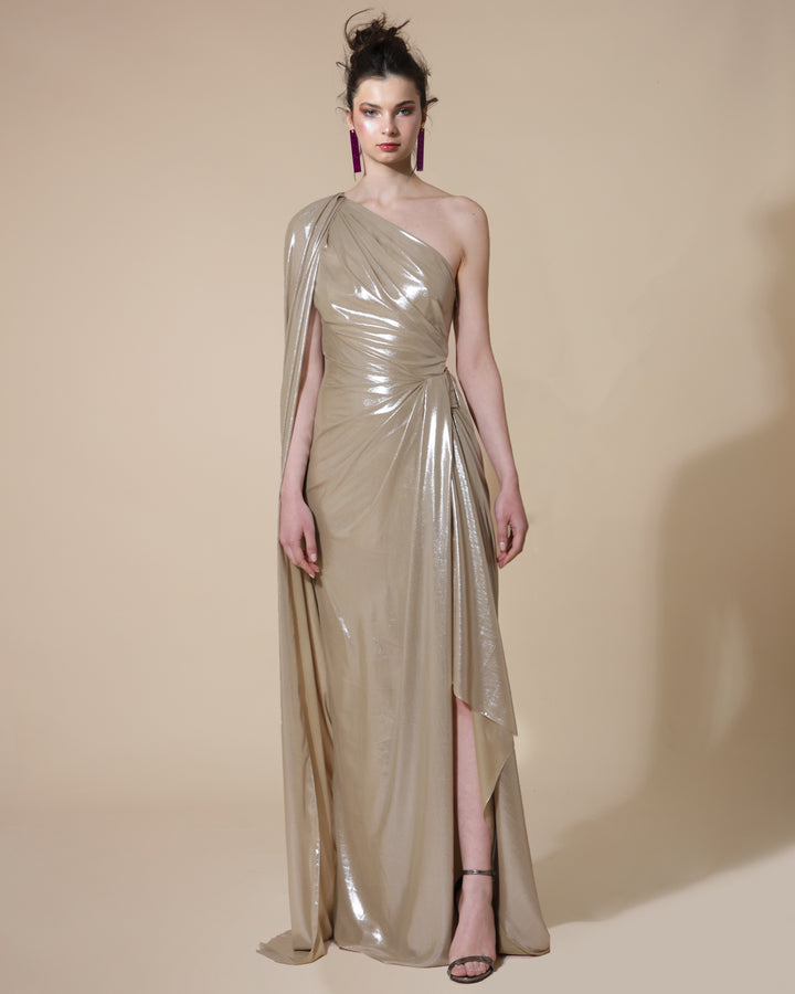 A fully draped long evening dress in metallic gold with a cape-like one sleeve and an overlapping side slit.