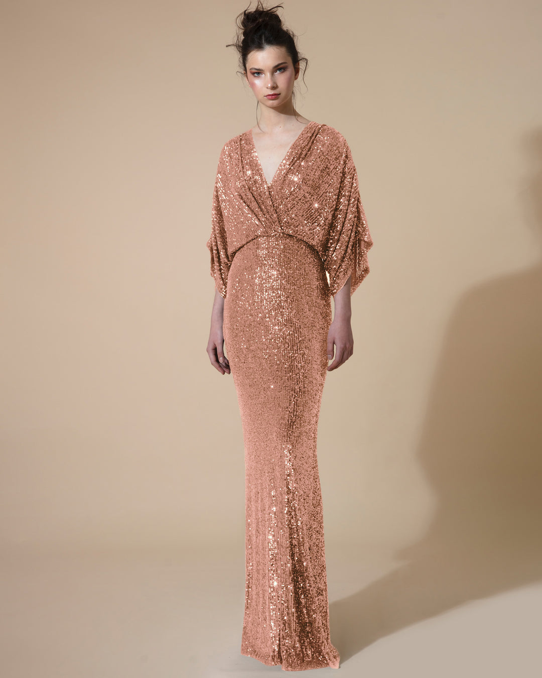 A long fitted evening dress in copper sequins fabric with gathered kimono sleeves, and a V neck.