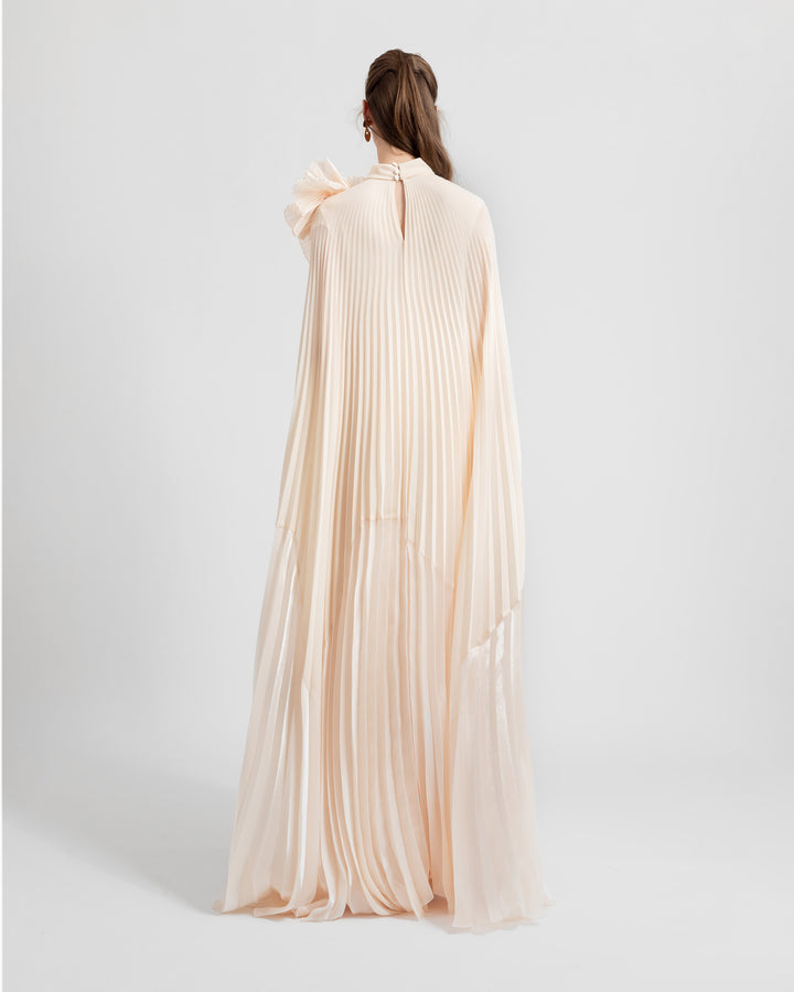 The back of a fully pleated lame organza flared beige dress.