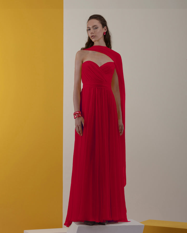 A strapless cut, chiffon red dress with pleating details and one shoulder cape-like flowy design.