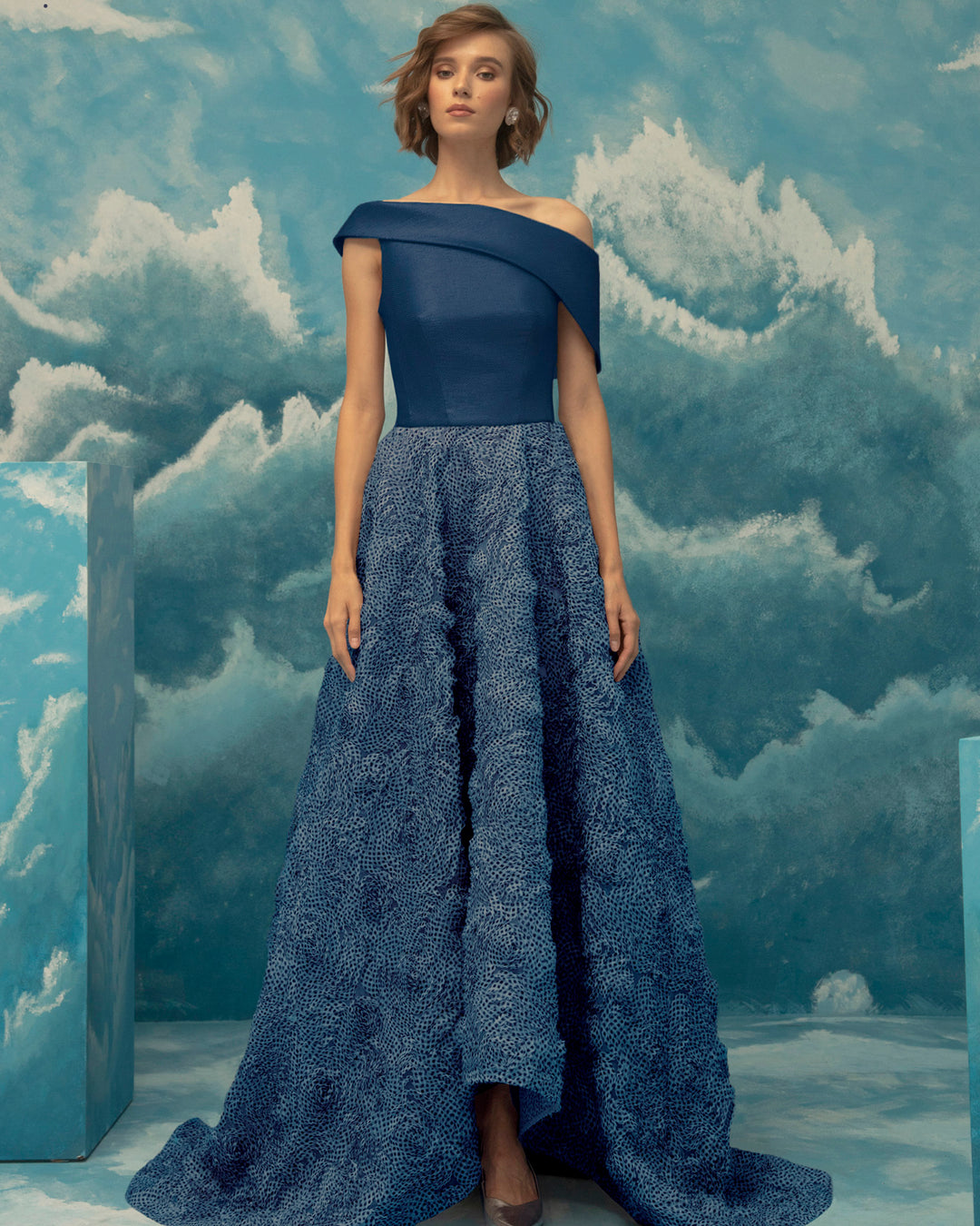 A bi-fabric blue evening dress, asymmetrical woven metallic fabric upper part and wide fluffy textured chiffon cut skirt.