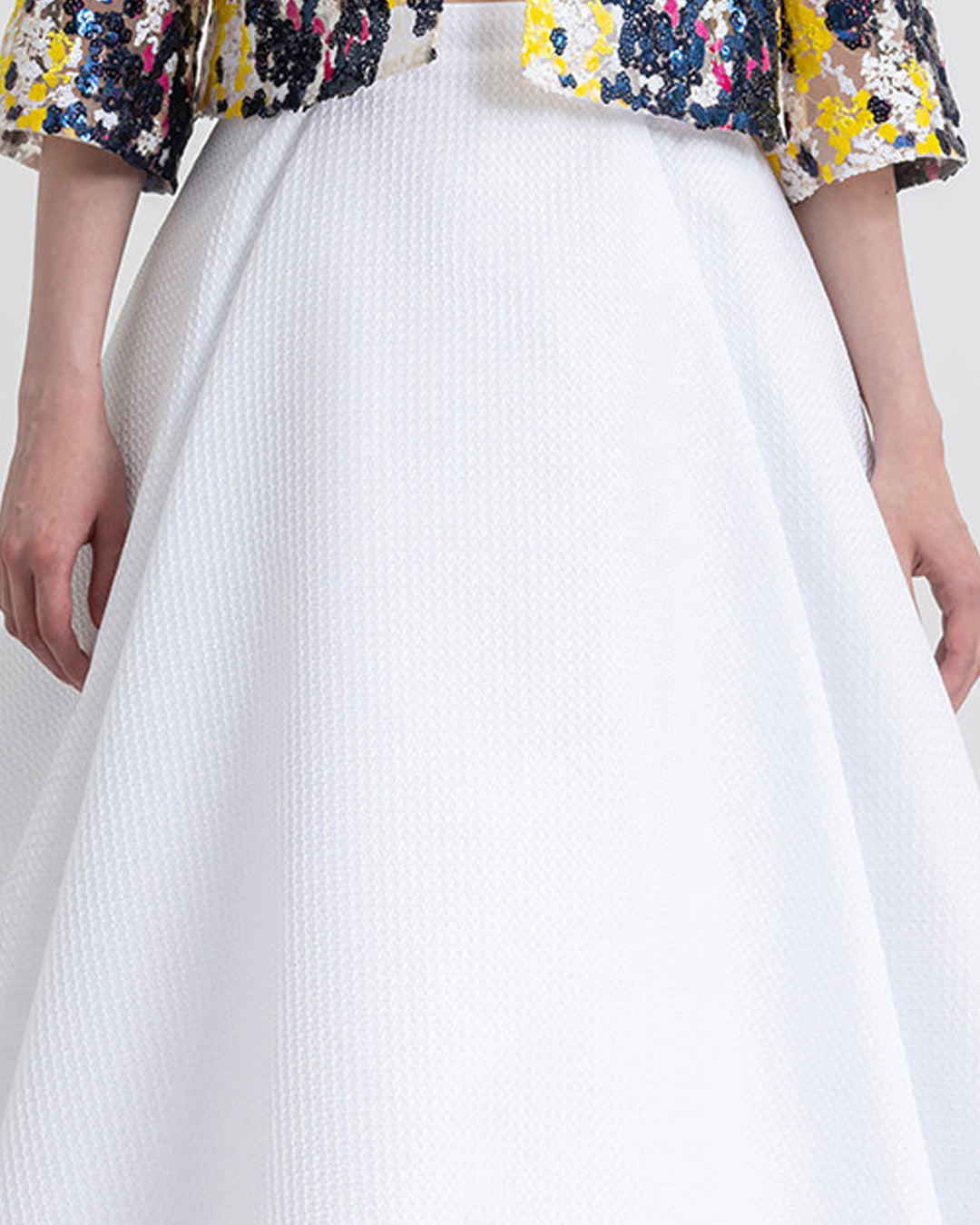 A close-up of a flared white skirt.