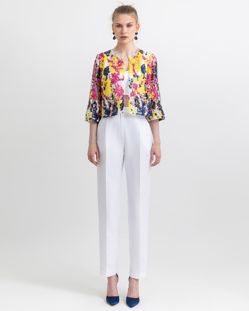 An occasion wear featuring a white cropped top paired with a multicolor sequins jacket and a straight cut white pants.