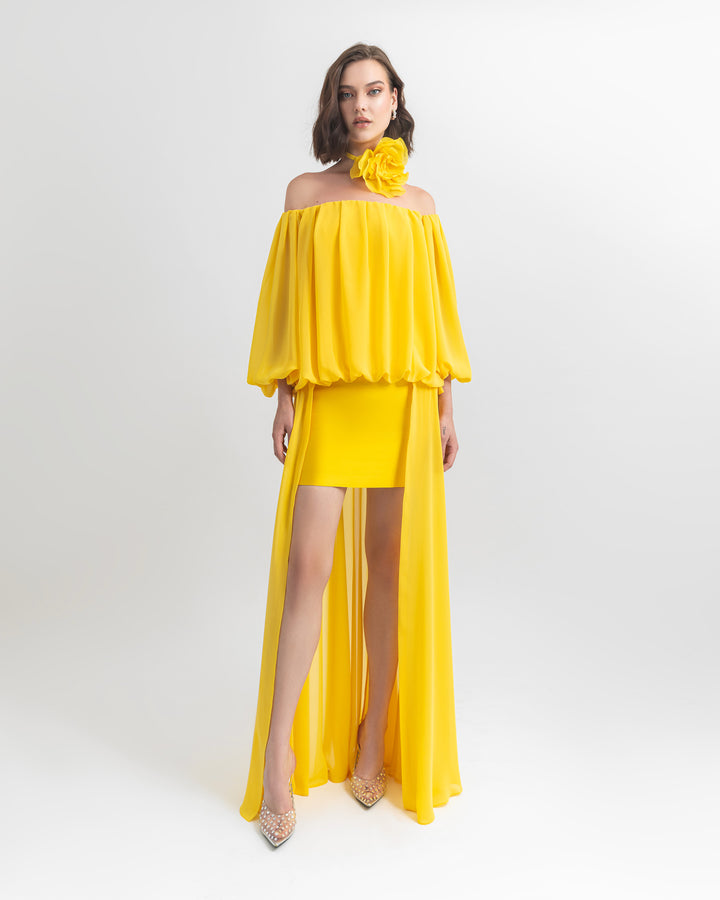 An off-shoulders, loose cut chiffon evening dress with an asymmetrical hemline complimented with  big yellow rose choker necklace.