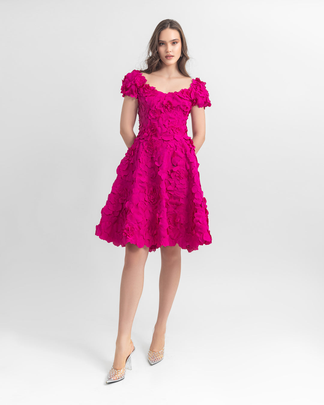 An evening wear set featuring a laser cut low-shoulder fuchsia top paired with a matching fuchsia skirt.