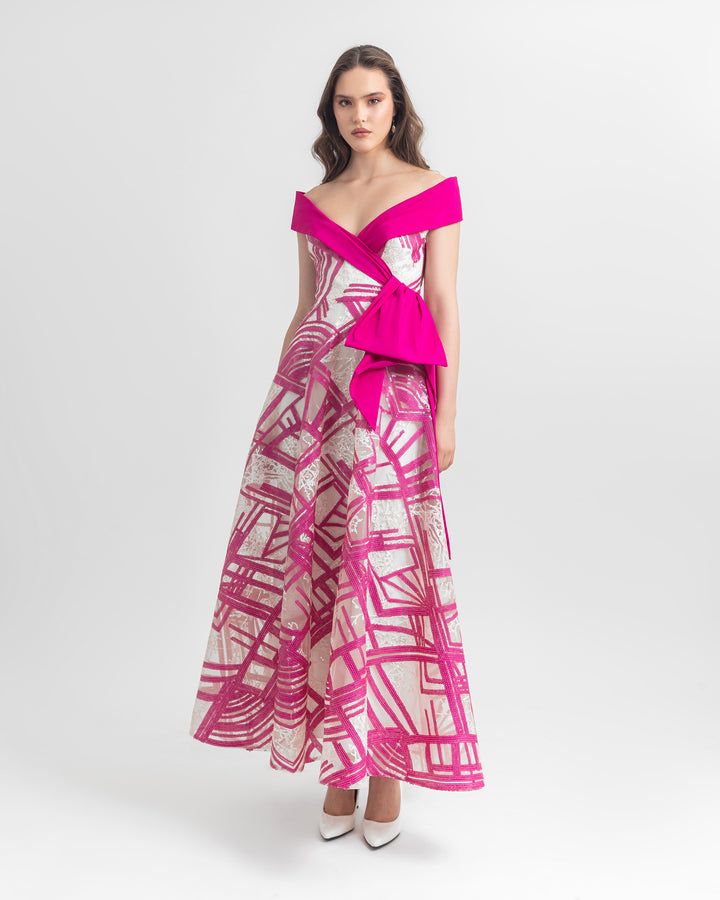 An off-shoulder sequins dress in white and fuchsia with bow detail on the side.