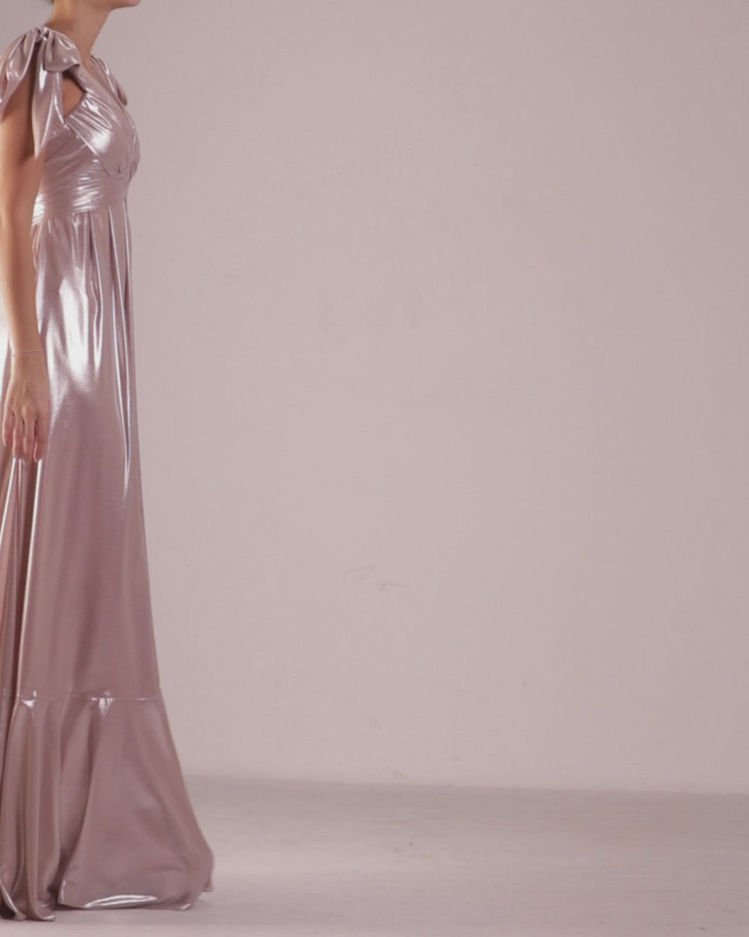 A draped upper part flared cut, laminated pink chiffon long dress with bow-design details on the shoulders.