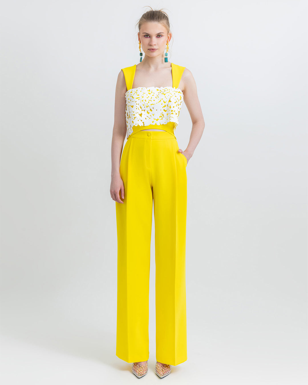 An occasion wear featuring a yellow straight cut crepe pants paired with a cropped crepe top with white laser-cut silicon.